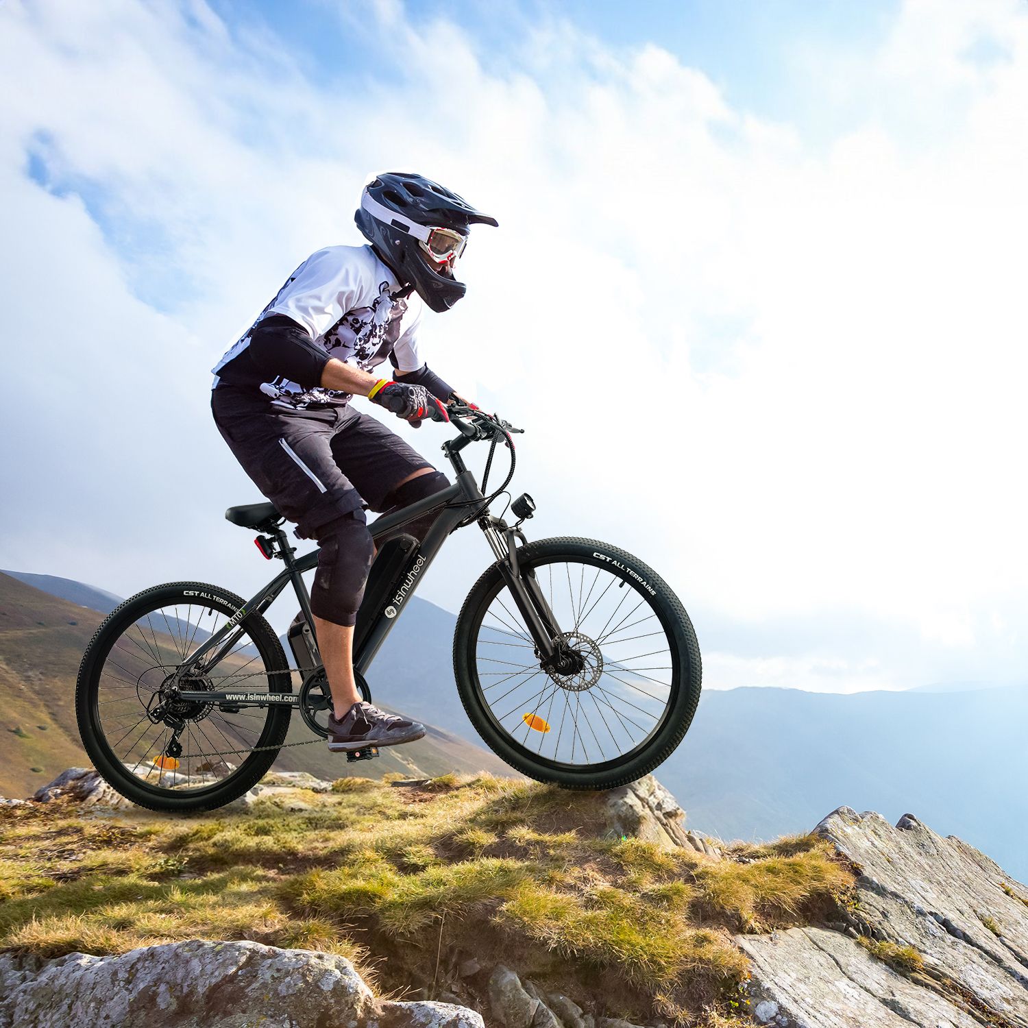 Persoon op zwarte e-bike op een berg. De fiets heeft zwarte banden en een zwart frame. De fietser draagt een helm.