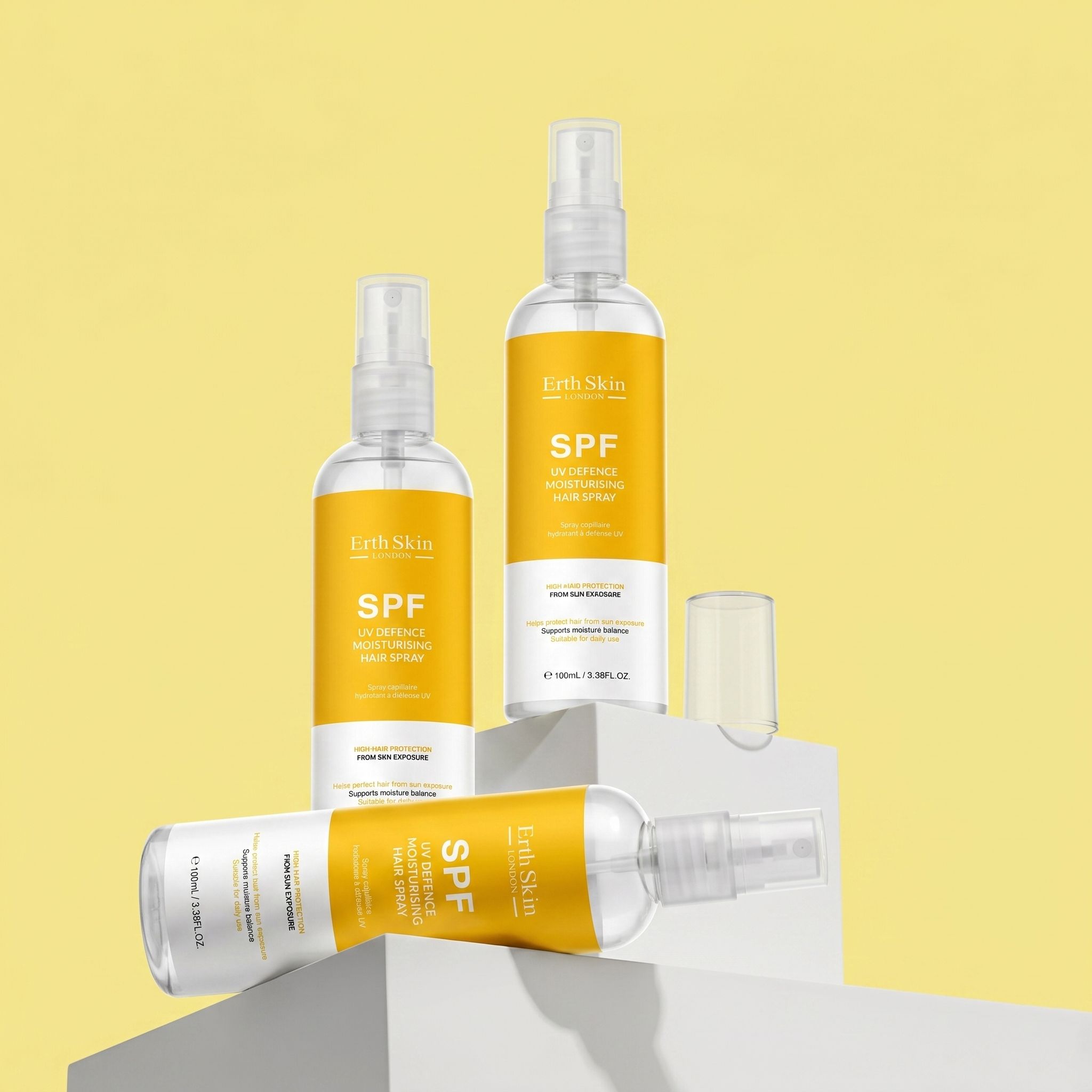 Plusieurs flacons de spray capillaire avec étiquettes jaunes. Inscription : SPF. Têtes de pulvérisation. ErthSkin London.