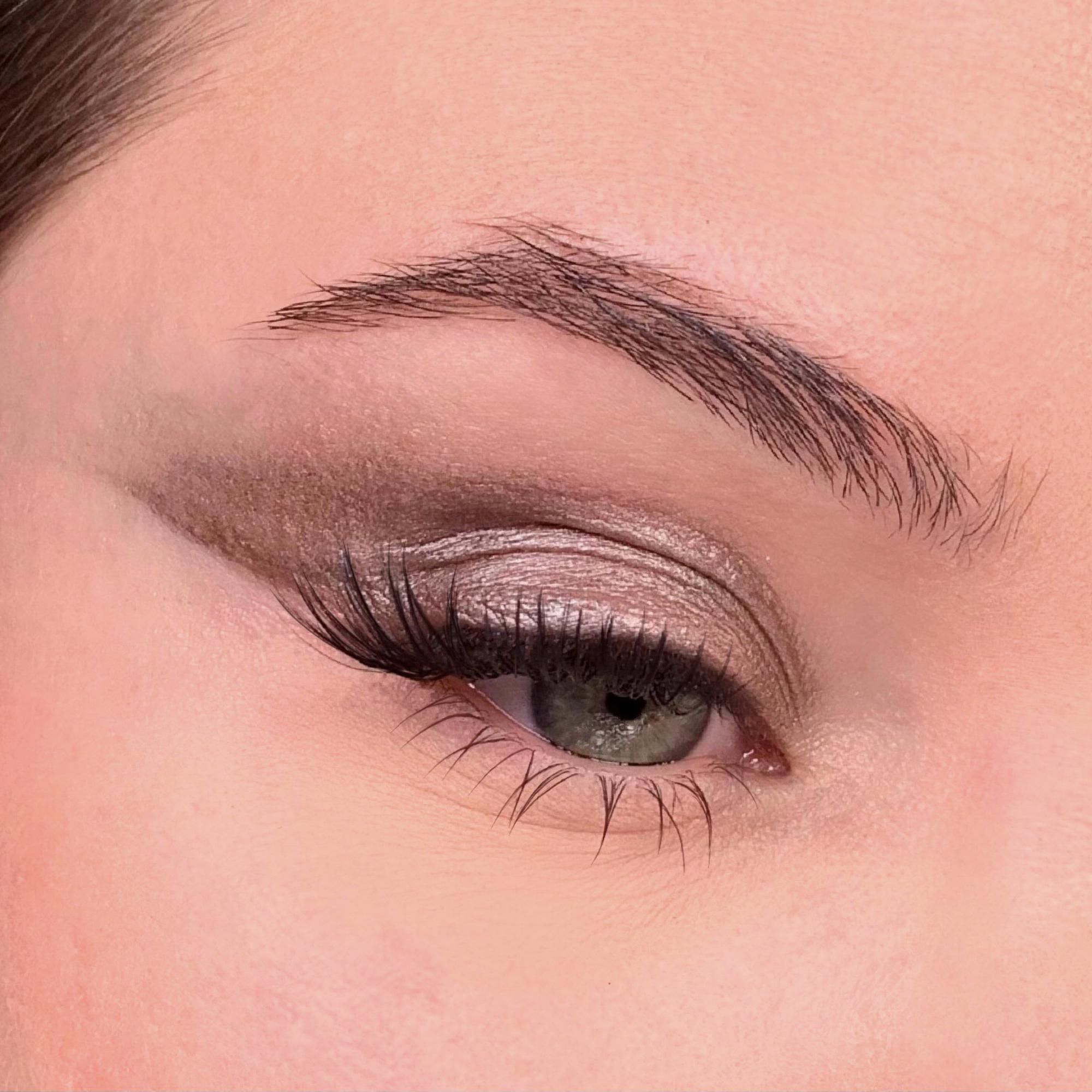 Close-up van een opgemaakt oog. Grijze oogschaduw. Wenkbrauw en wimpers.