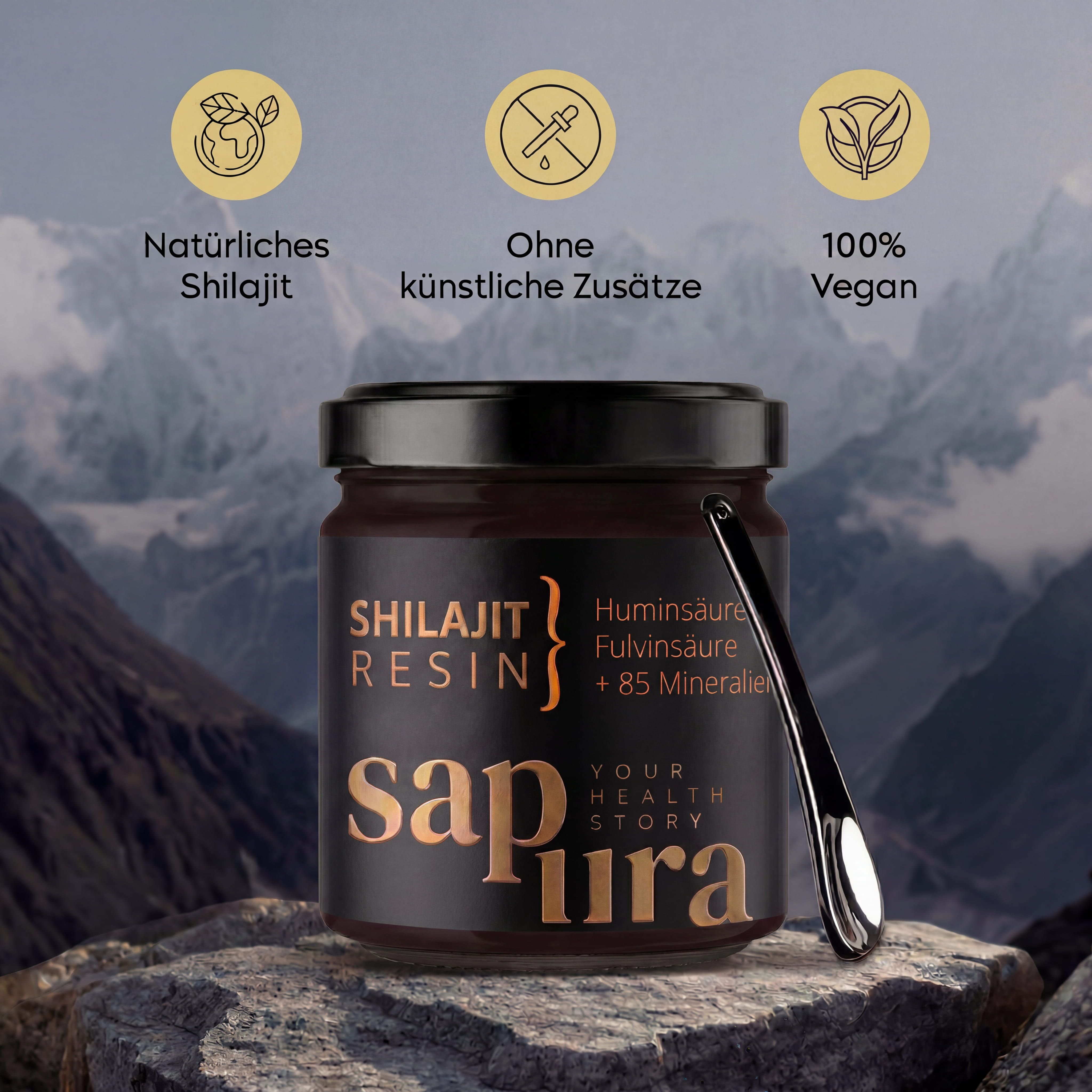 Shilajit Resin en bocal avec cuillère doseuse, devant un paysage montagneux, avec icônes 'Naturel', 'Sans additifs', 'Vegan'.