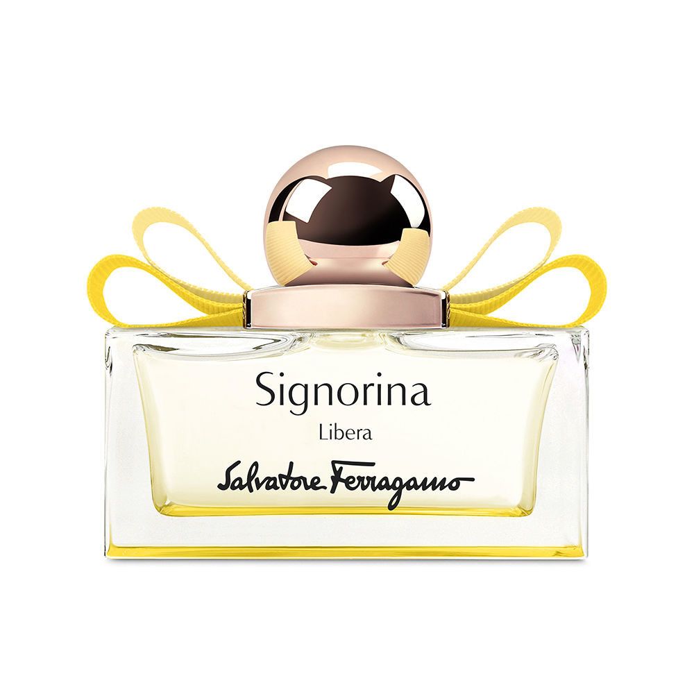 Flacon de parfum rectangulaire avec liquide jaune, bouchon doré et ruban jaune. Texte Signorina Libera et Salvatore Ferragamo.