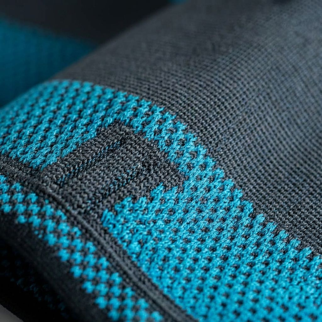 Gros plan sur la bande de cuisse. Textile bleu et noir. Motif carré. Vue détaillée.