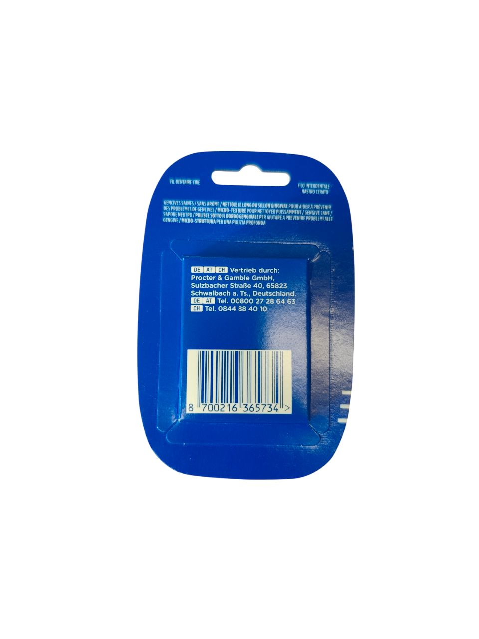 Dos du paquet de fil dentaire. Emballage bleu avec texte et code-barres. Informations du fabricant.