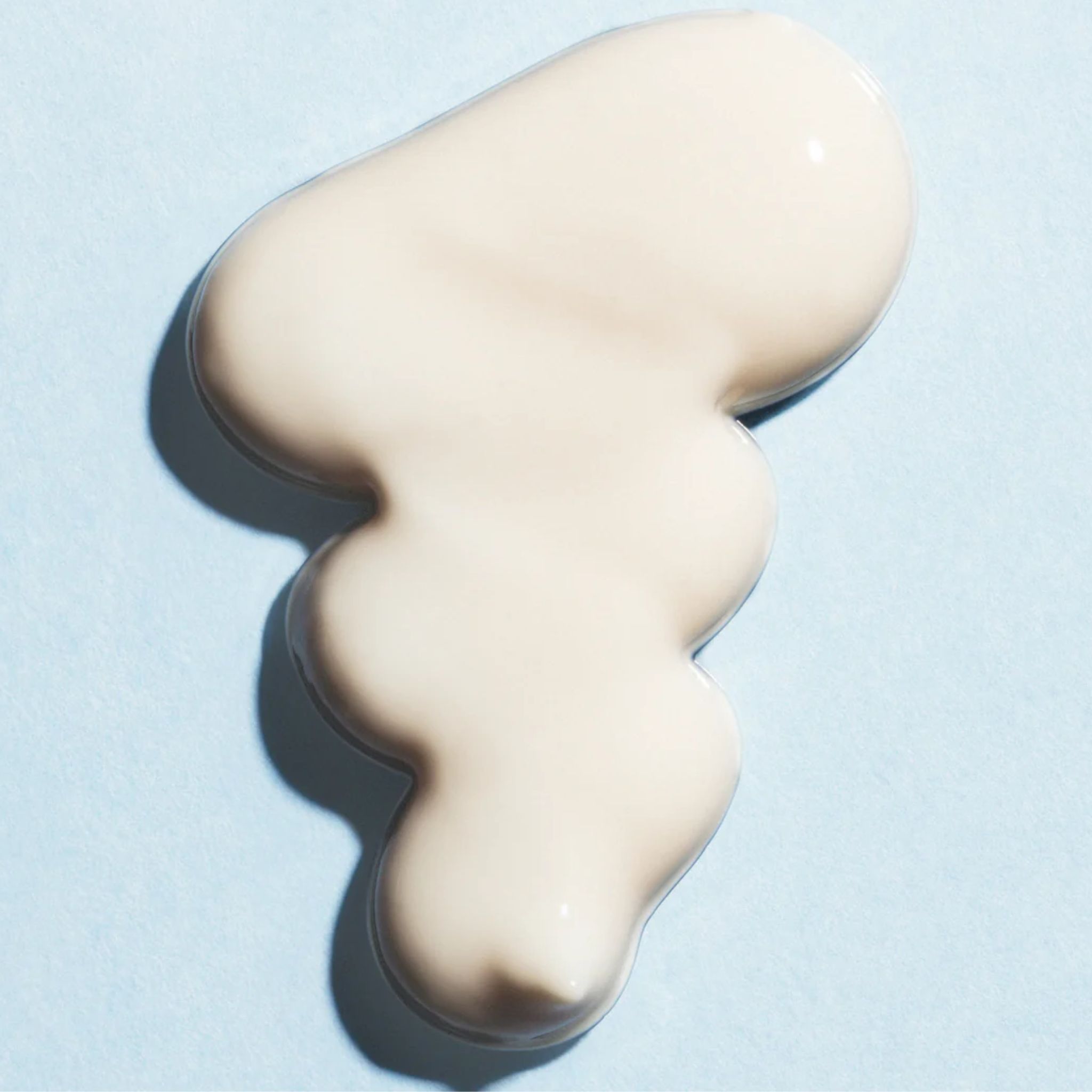 Tache crème claire sur fond bleu clair. Ombre portée.