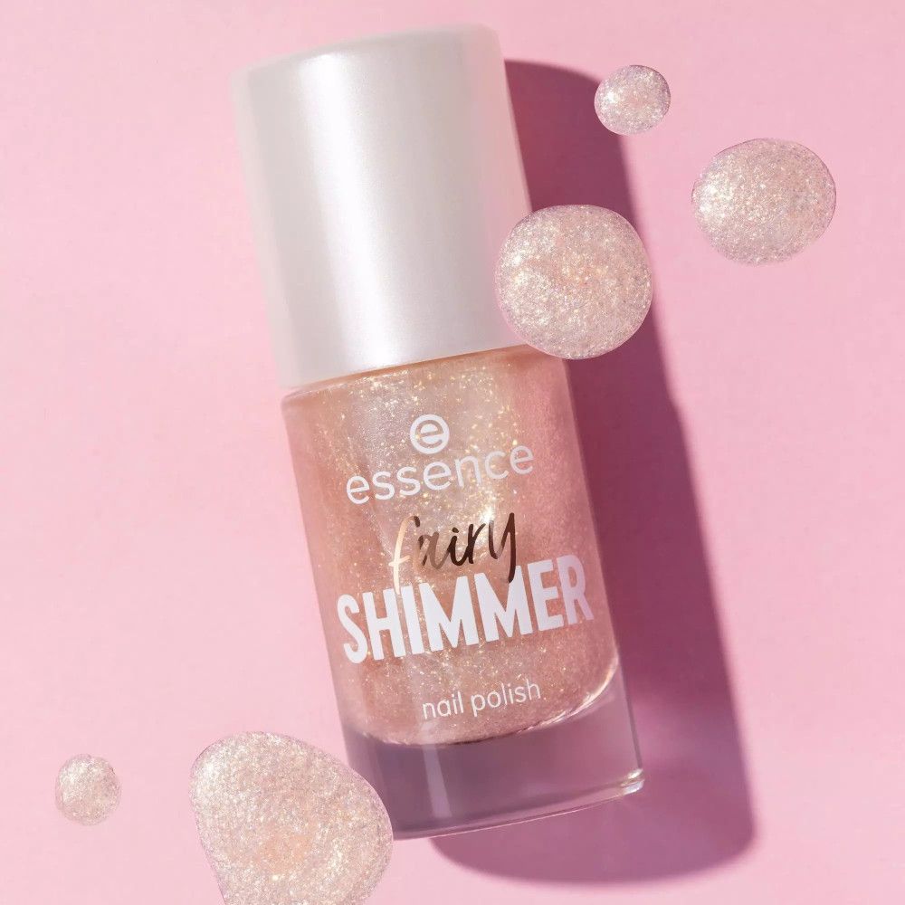 Flacon de vernis à ongles rose scintillant avec des sphères flottantes. Inscription: Fairy Shimmer.