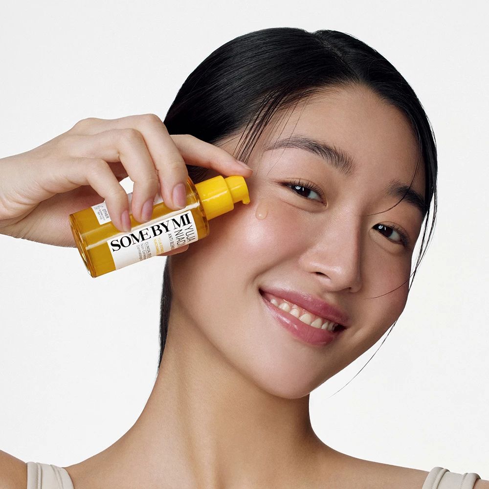 Vrouw houdt serumfles vast. Brengt serum aan op de huid.