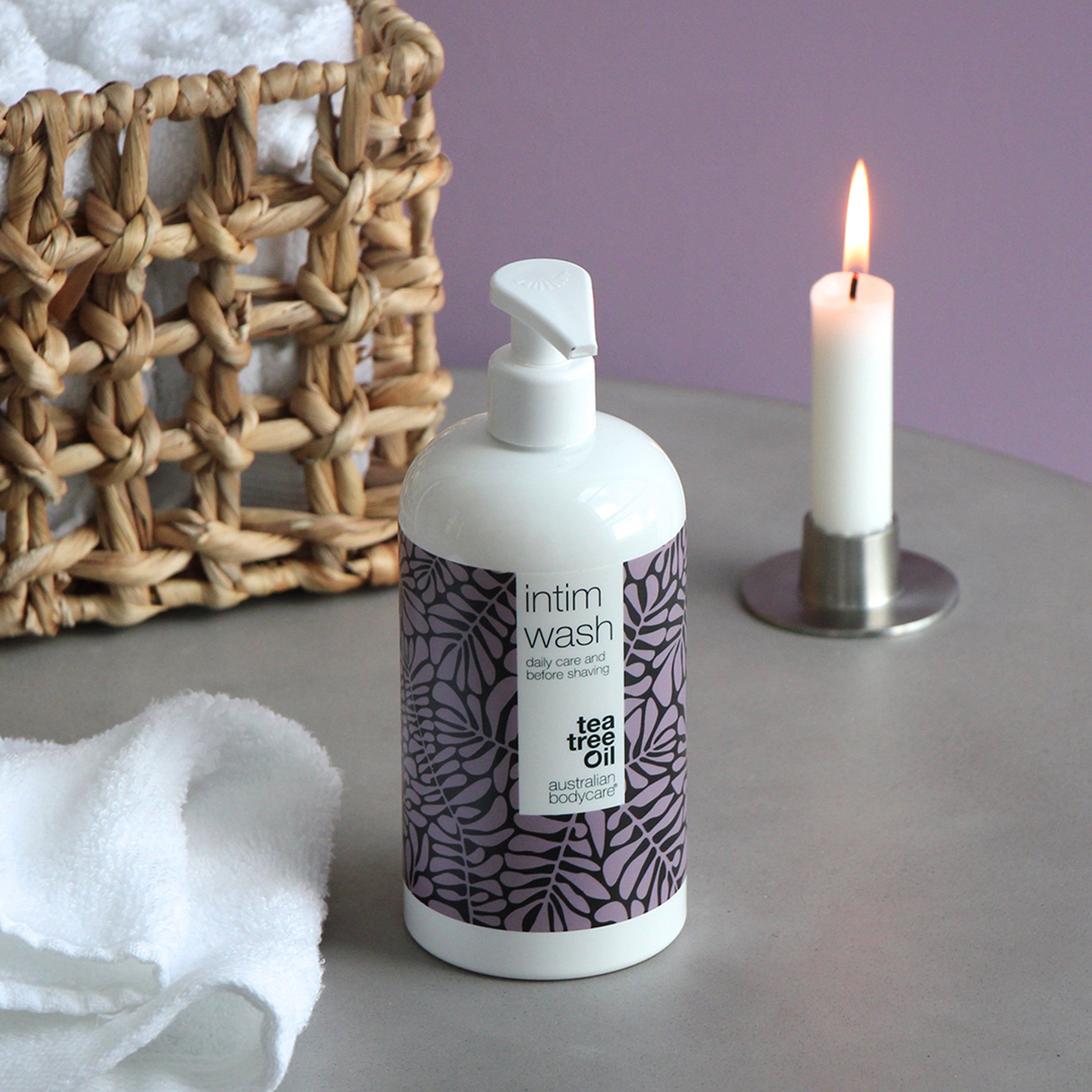 Witte fles intieme wasgel. Paars bladerpatroon. Opschrift: Intim Wash, daily care & before shaving, Australian Bodycare. Kaars.