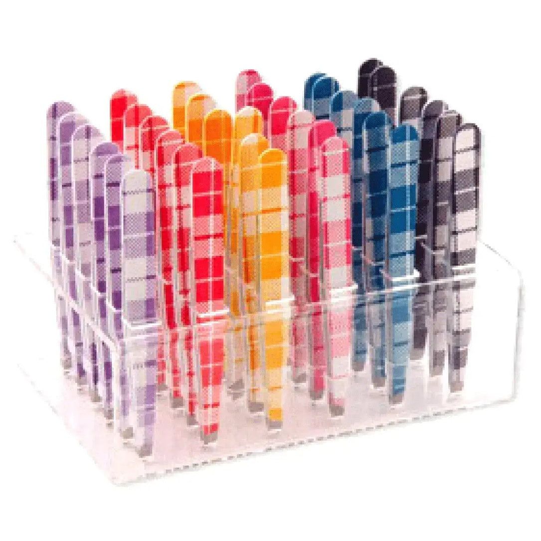 Présentoir transparent contenant plusieurs pinces à épiler. Les pinces ont des manches colorés à carreaux.