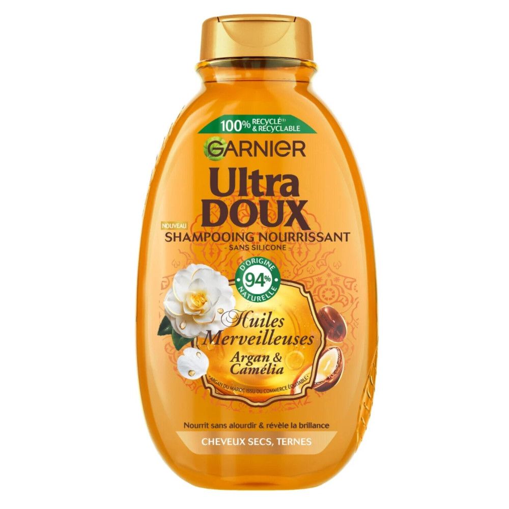 Oranje shampoo fles. Opschriften: Garnier Ultra Doux, Huiles Merveilleuses, Argan & Camélia. 94% natuurlijke ingrediënten.