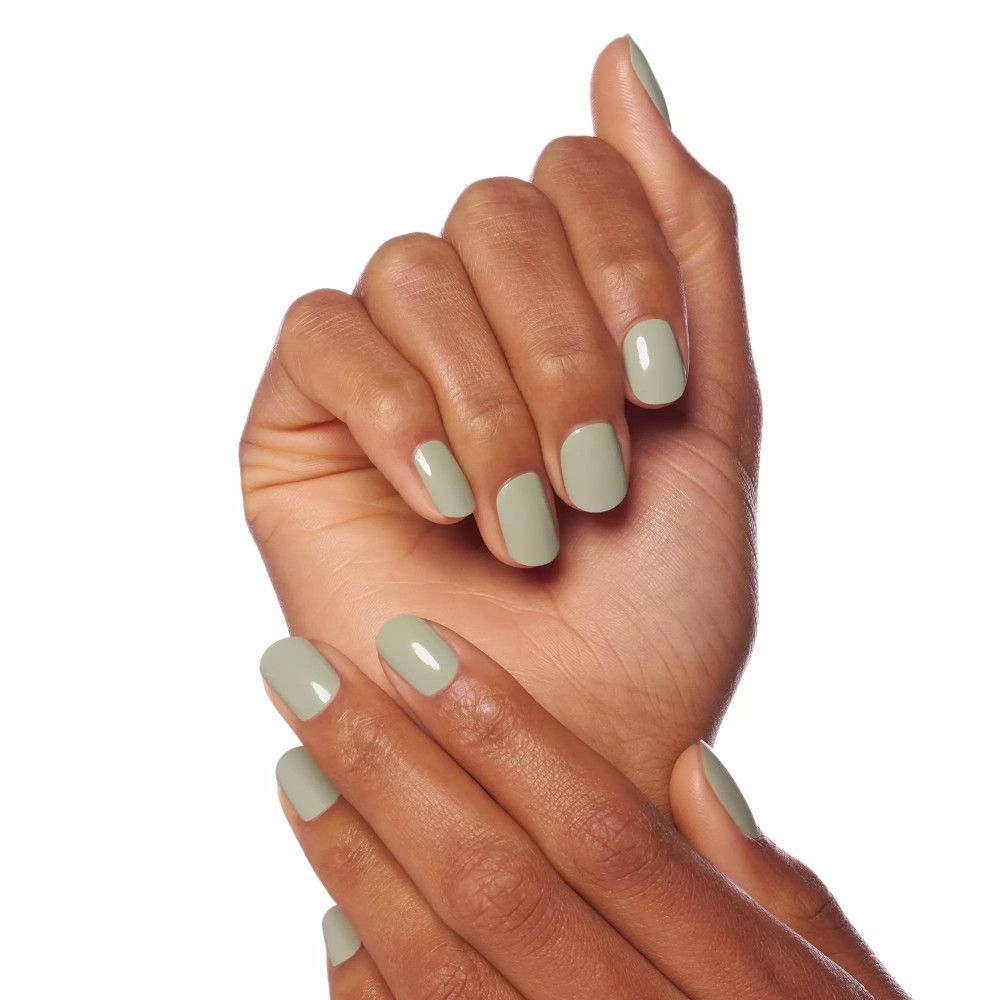 Mains avec des ongles peints en vert clair. Les ongles sont courts et carrés.