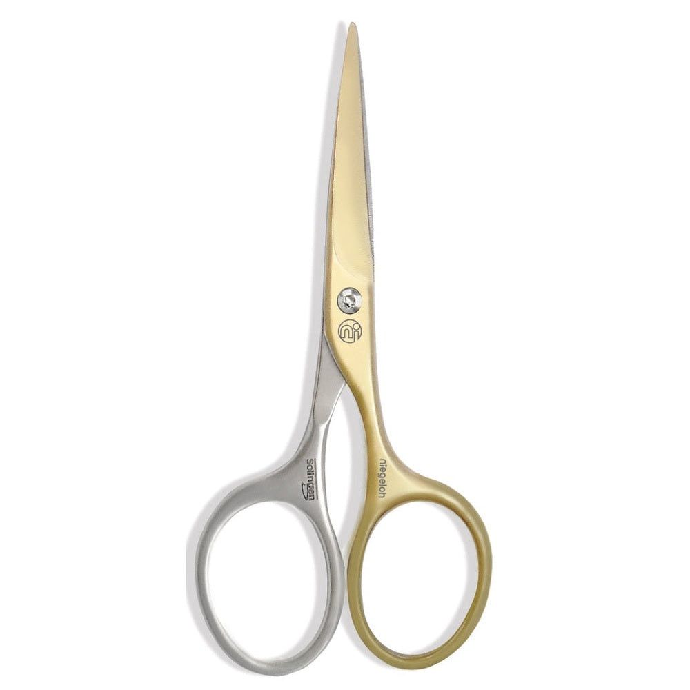 Schaar met goudkleurige en zilverkleurige handgrepen. Logo's en opschriften zijn zichtbaar op de schaar.
