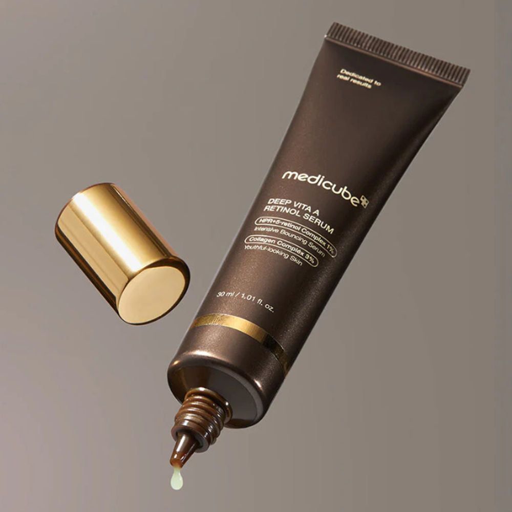 Tube ouvert Medicube Deep Vita A Retinol Serum avec goutte. Bouchon doré à côté.