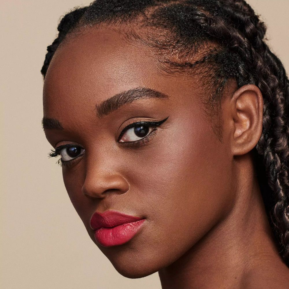 Portret van een vrouw met rode lippenstift. Donkere huid, gevlochten haar, eyeliner.
