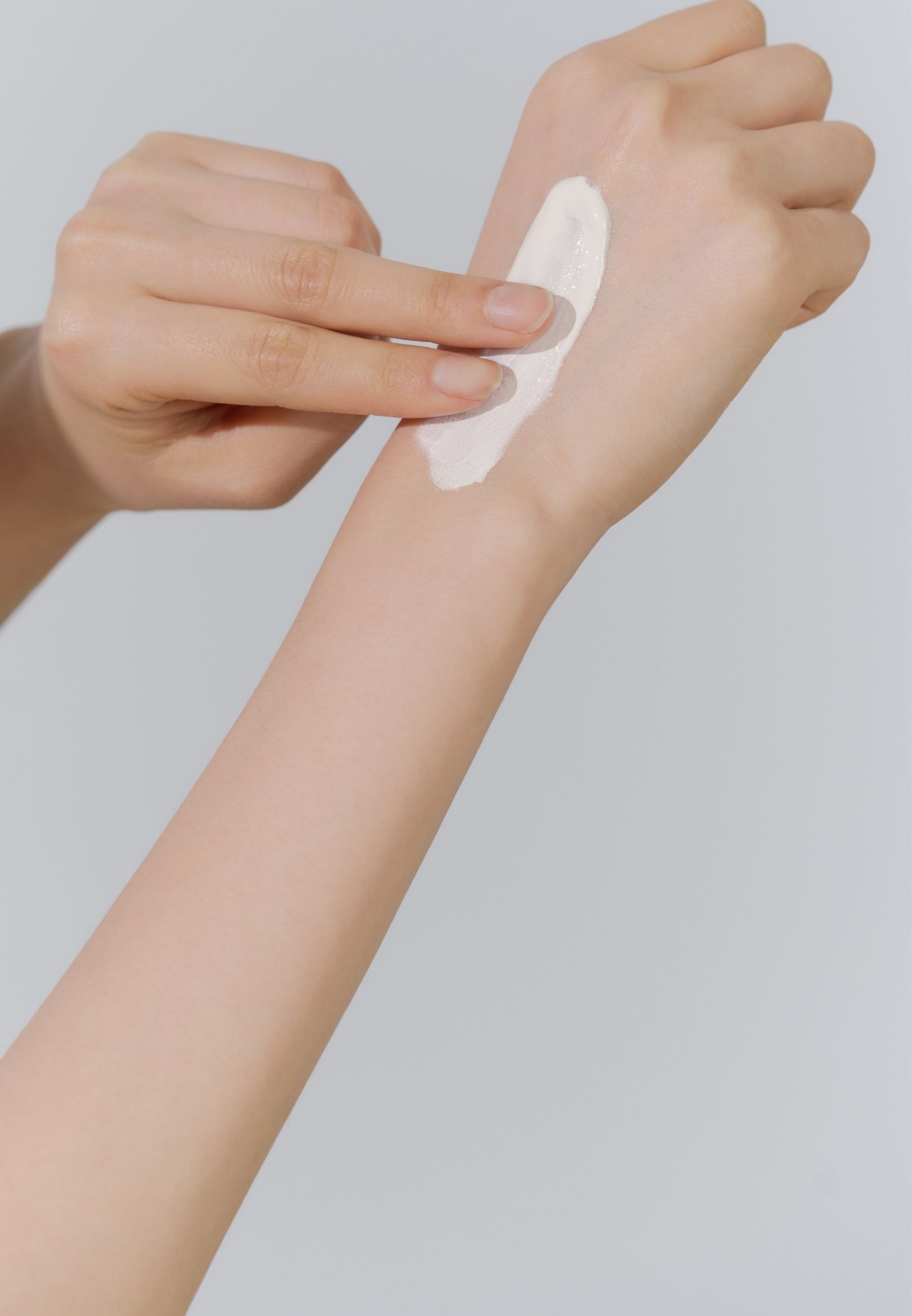 Main avec crème sur la peau. Aucun autre détail visible.