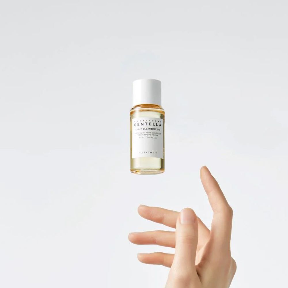 Transparante olie in een klein flesje met witte dop. Hand reikt naar flesje.