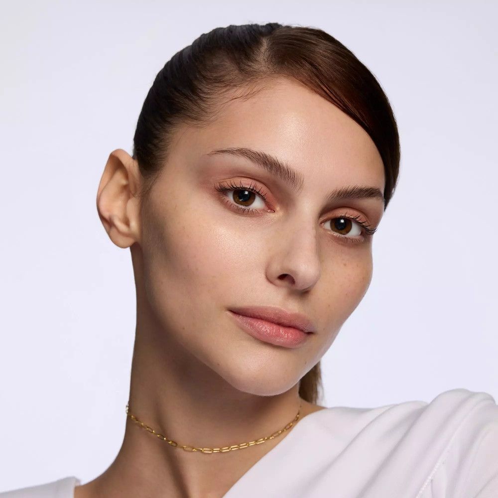 Portrait d'une femme. Elle porte un collier en or.