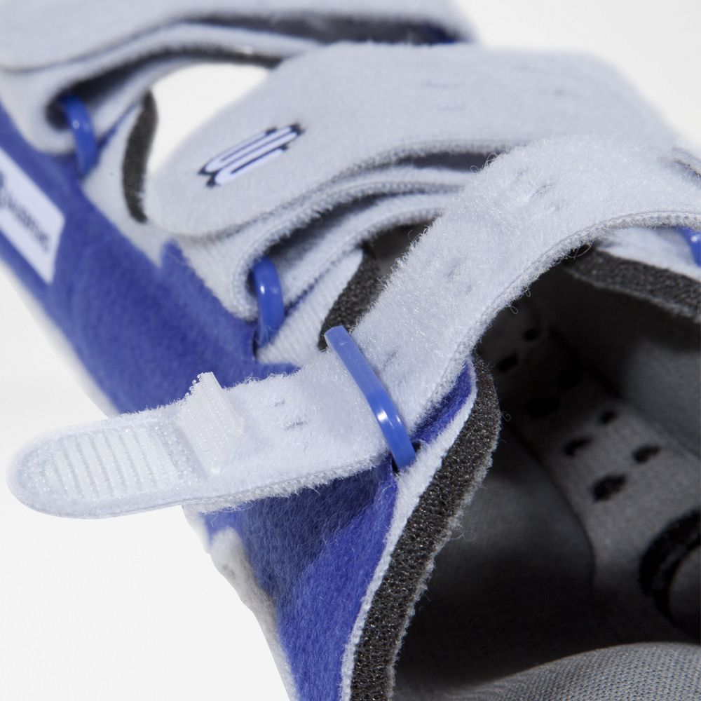 Close-up van de polsbrace. Blauwe en witte materialen, klittenbandsluiting en blauwe plastic ringen.
