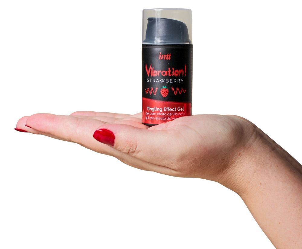 Fles in hand gehouden. Productnaam: Vibration! Strawberry Tingling Effect Gel. Merk: INTT. Zwarte fles met rode tekst.
