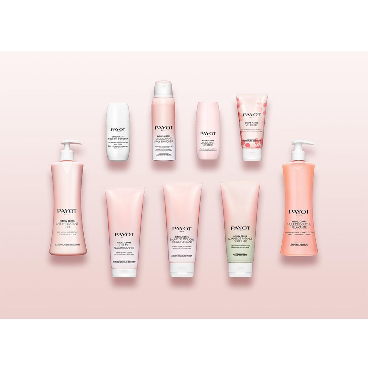 Opstelling van diverse Payot lichaamsverzorgingsproducten op roze achtergrond. Verschillende vormen en maten, waaronder tubes, flacons en sprays.