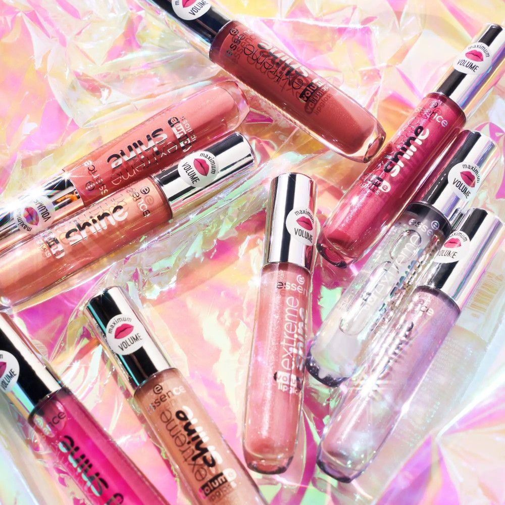 Meerdere lipgloss tubes. Opschrift: Extreme Shine, Volume Lipgloss. Op de dop: sticker met lippensymbool en Volume. Op glanzende achtergrond.