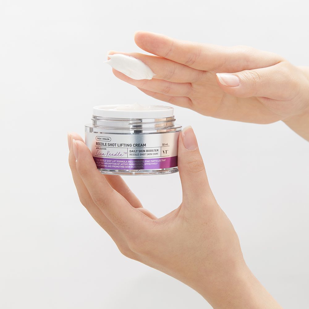 Handen houden een open glazen pot met crème vast. Een klodder crème op een hand. De pot heeft een zilveren deksel en paarse accenten.