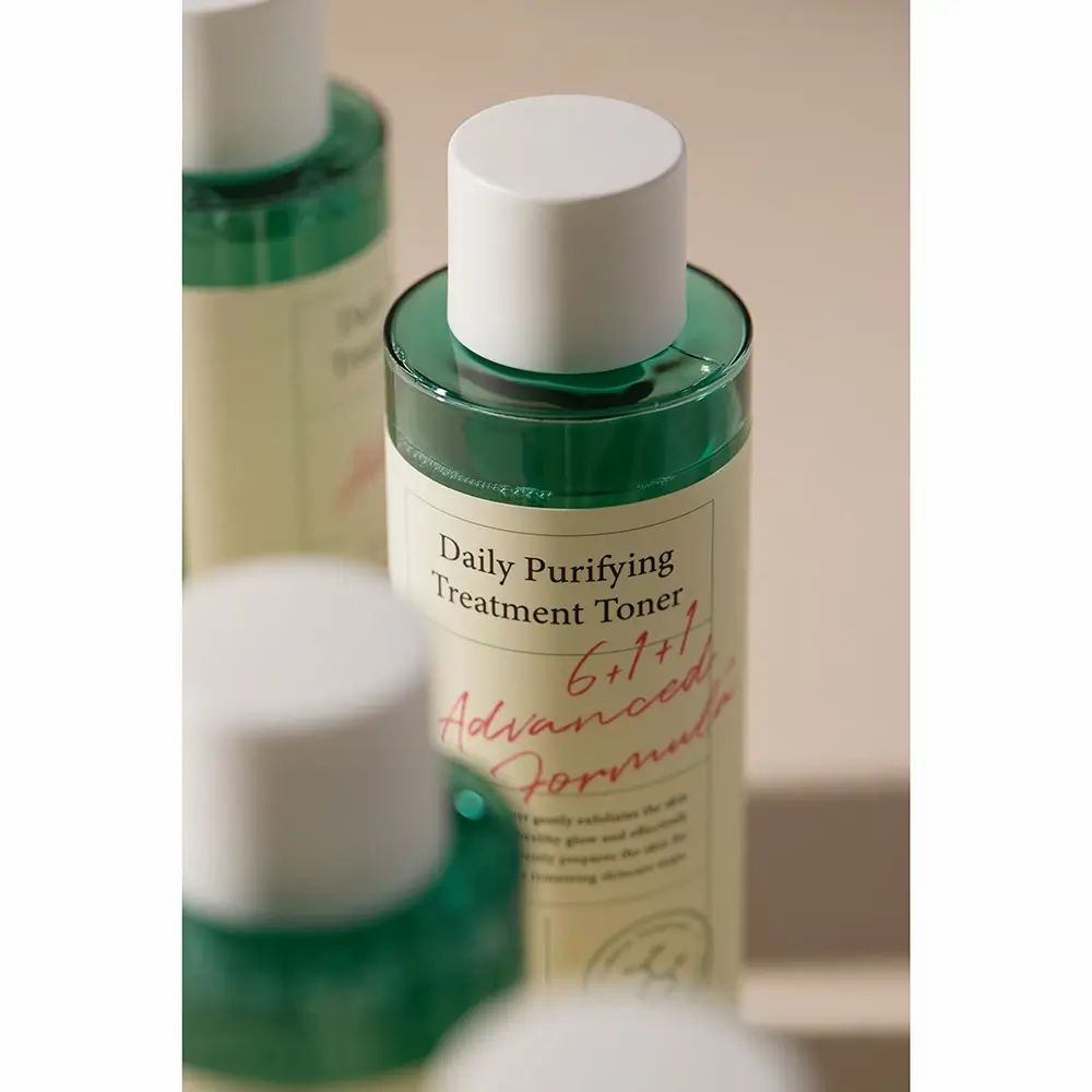 Meerdere flessen AXIS-Y Daily Purifying Treatment Toner. Witte doppen, groene vloeistof, wit etiket met tekst. Opschrift: 6+1+1 Advanced Formula.