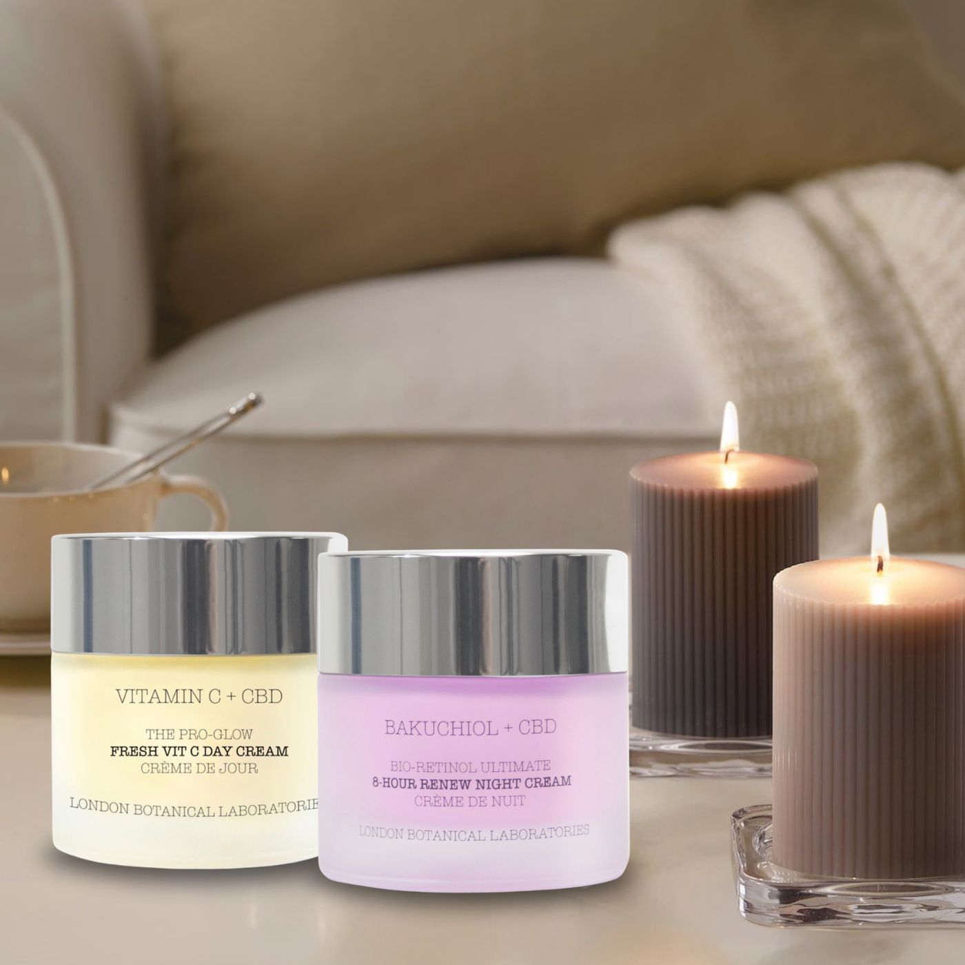 Deux pots de crème de jour et de nuit à côté de bougies allumées. Inscription : Vitamin C + CBD, Fresh Vit C Day Cream, London Botanical Laboratories. Bakuchiol + CBD, 8-Hour Renew Night Cream.