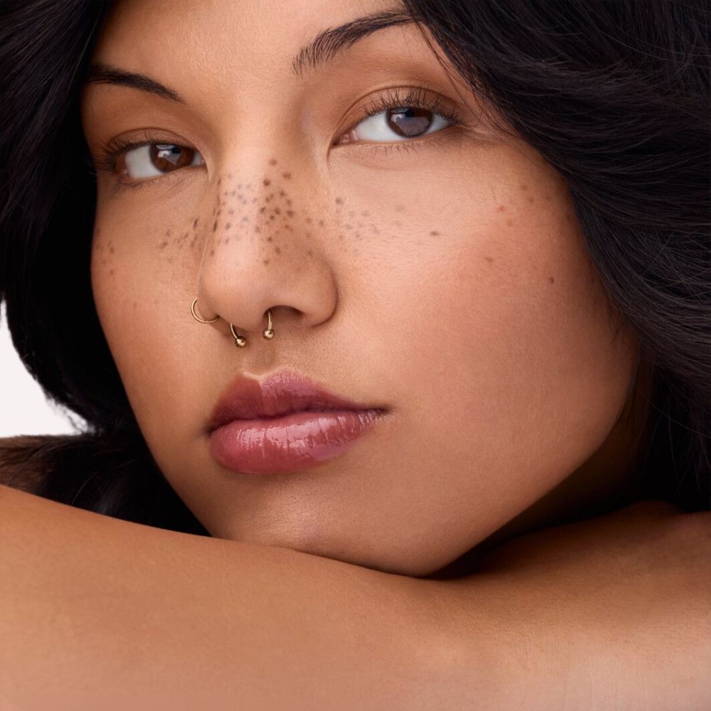 Portret van een vrouw met lippen bedekt met lipgloss. De lippen zijn roodbruin.