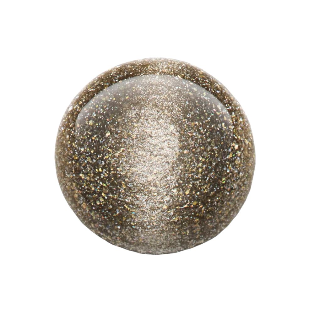 Boule de vernis à ongles. Surface brillante avec particules dorées. Sur fond blanc.