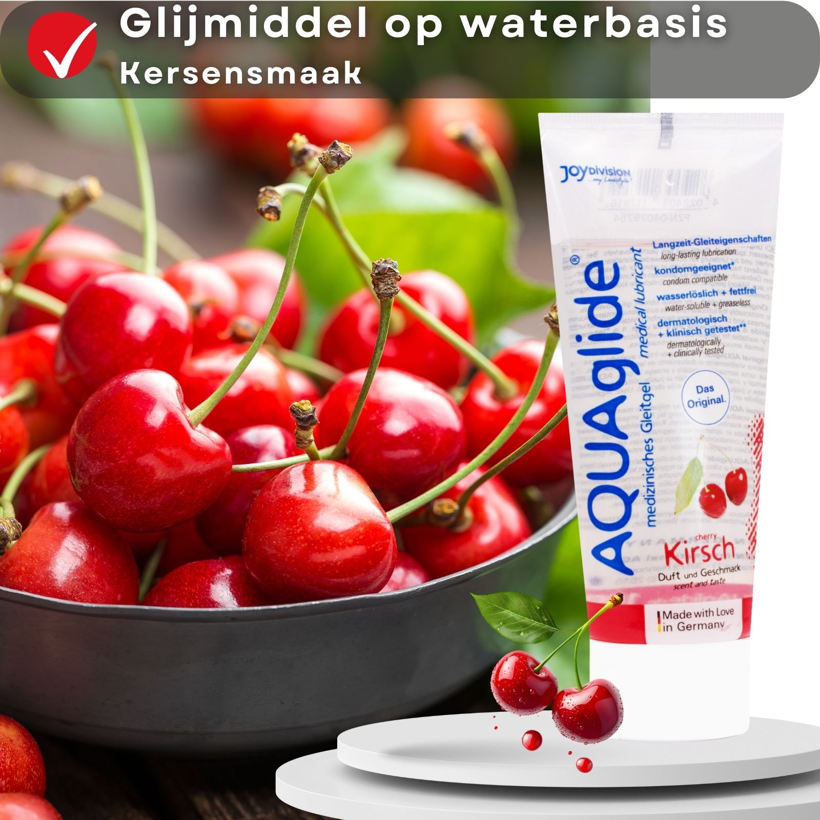 Producttube AQUAglide, Kirsch, naast kersen in schaal. Kersen op wit voetstuk.
