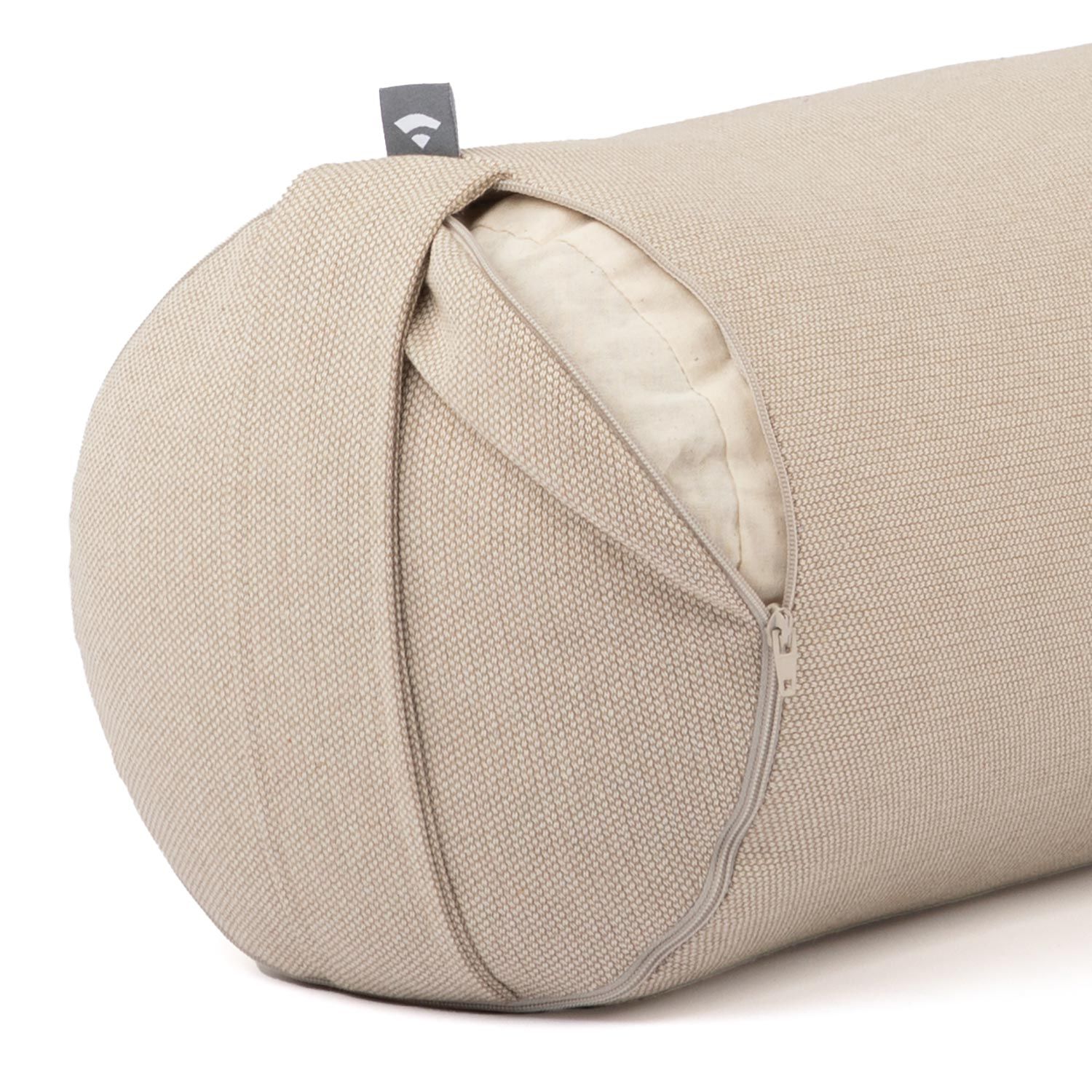 Close-up van een yoga bolster. Beige stoffen hoes met rits. Klein label. Binnenvoering zichtbaar.
