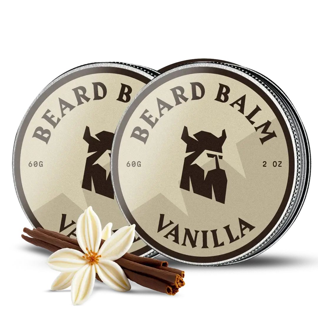Twee ronde blikken met deksels, opschrift "BEARD BALM" en "VANILLA". Daarnaast een vanillebloem en kaneelstokjes.
