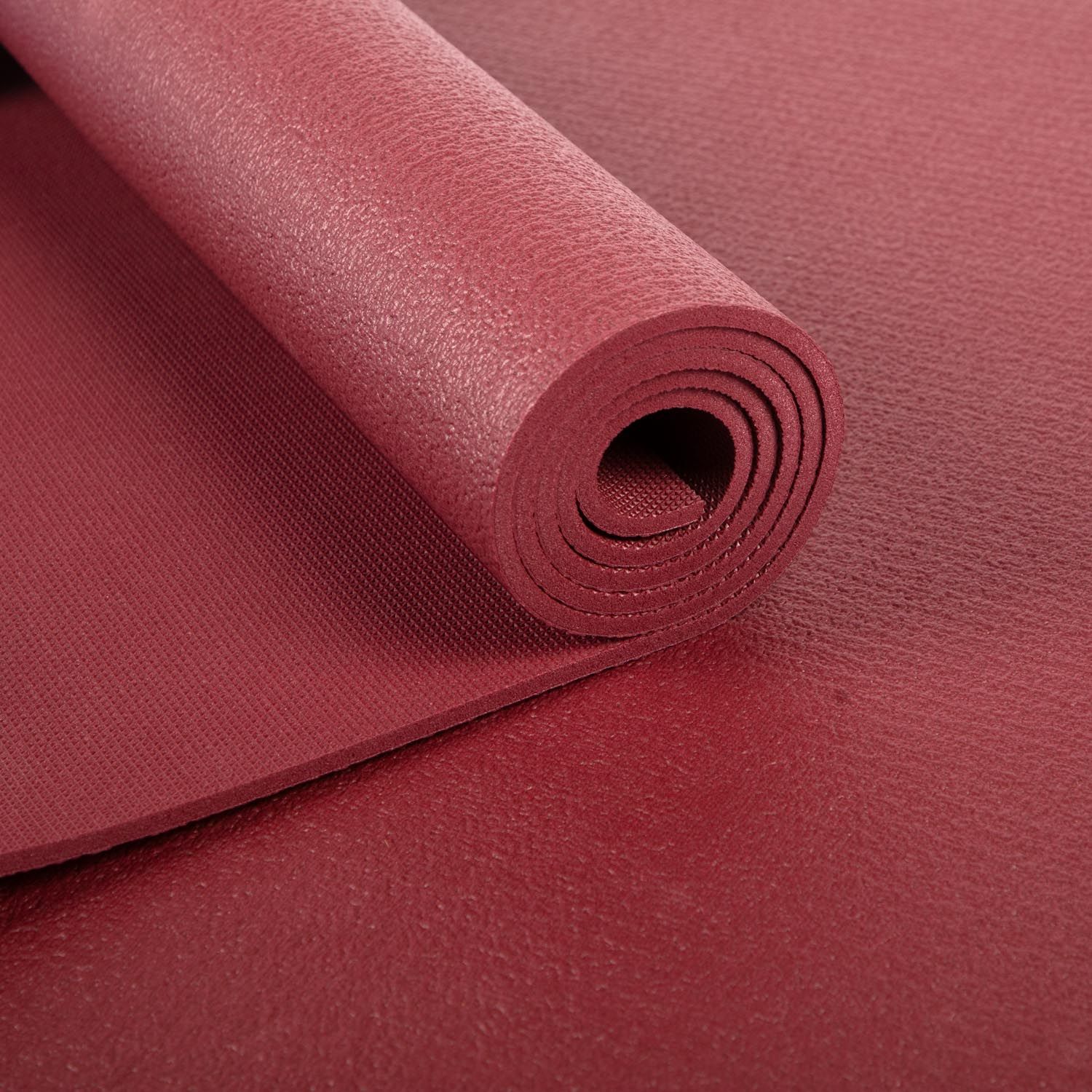 Bordeaux yogamat, opgerold. Close-up van het opgerolde oppervlak.