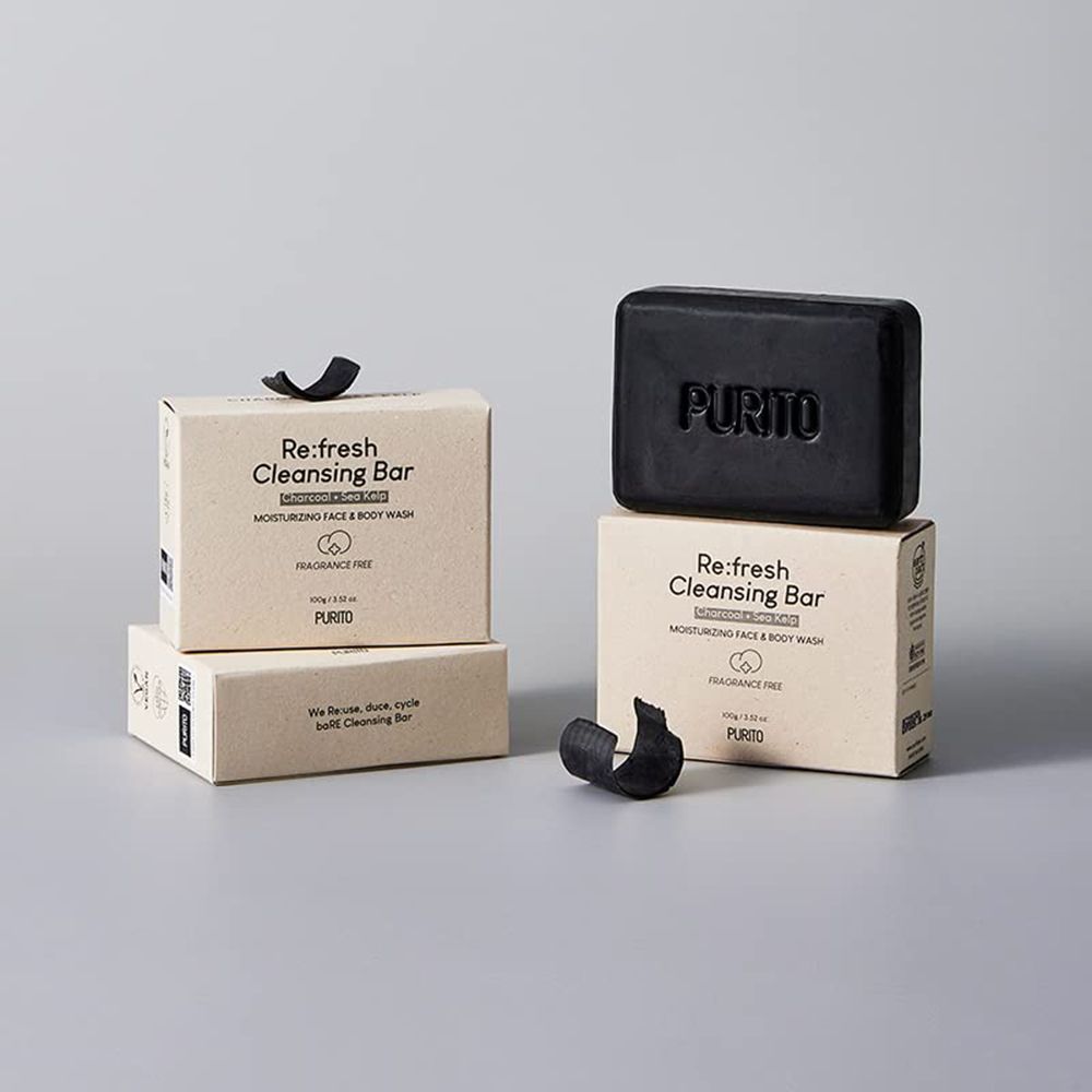 Twee dozen met zwarte zeep. Op de doos staat 'Re:fresh Cleansing Bar' en 'PURITO'. Een zwart lint.