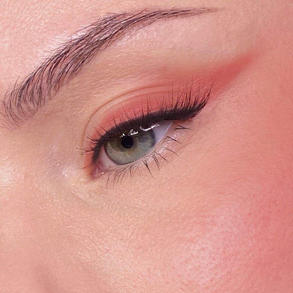 Close-up van een oog met oogschaduw en mascara. Lichte huidskleur. Wenkbrauw zichtbaar.