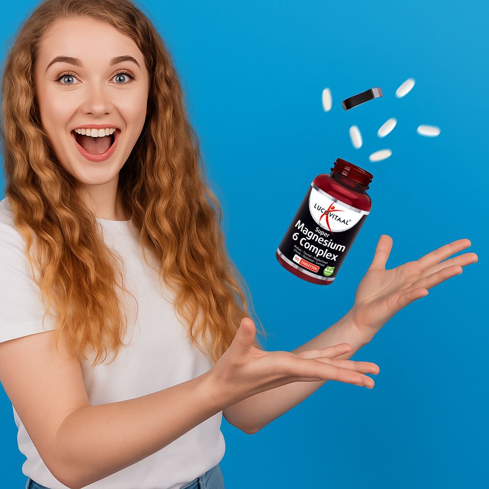 Une femme tient une bouteille et des comprimés. La bouteille indique 'Lucovitaal Magnesium 6 Complex'. Fond bleu.