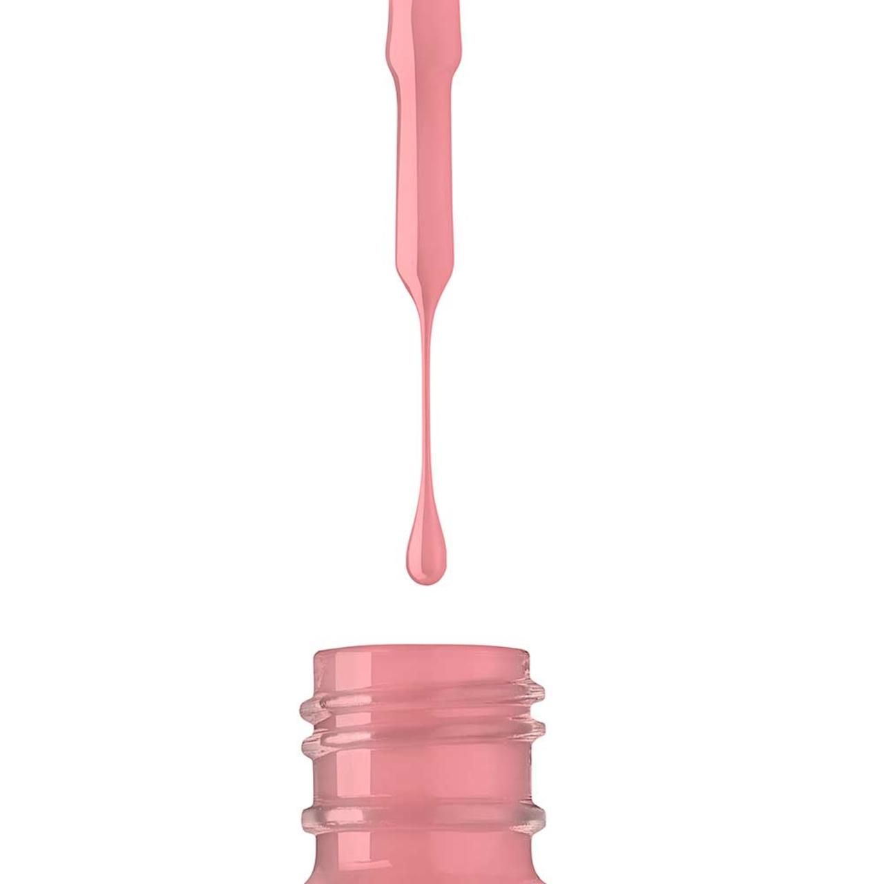 Nagellak druppelt uit de fles. Roze vloeistof. Detailopname.