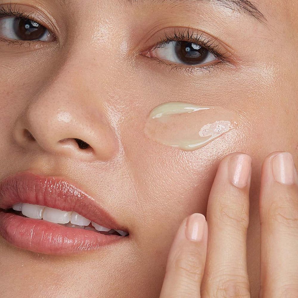 Gros plan d'une femme appliquant un produit sur son visage. Substance gélifiée sur la peau.
