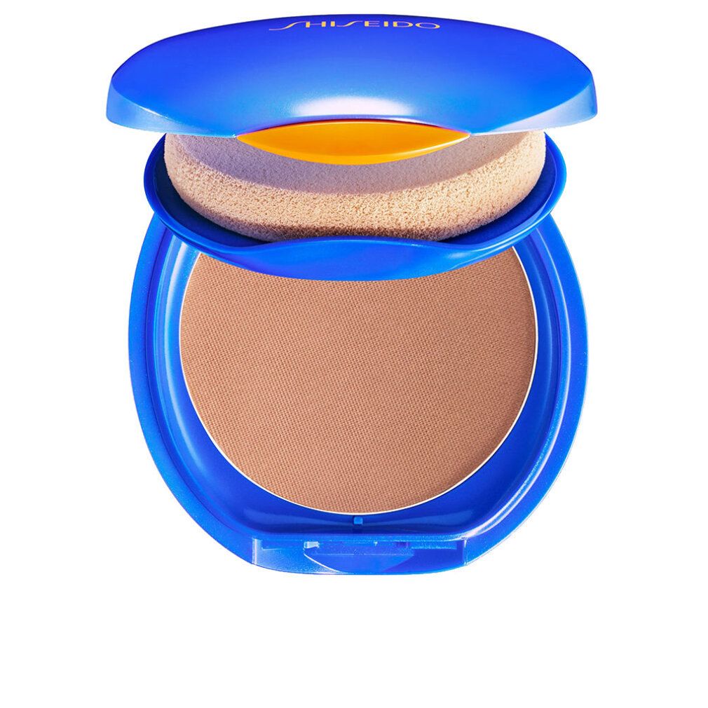 Boîtier compact bleu ouvert. Contient une éponge et une poudre brune. "Shiseido" est écrit en haut.