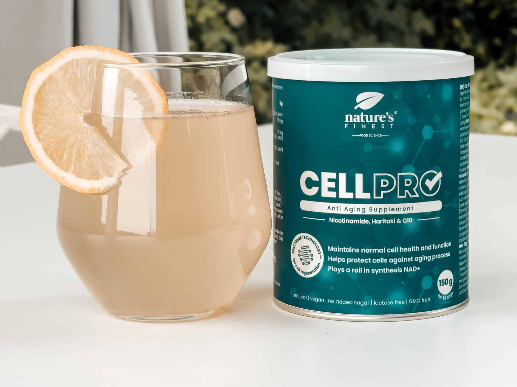 Verre avec boisson et citron, boîte Nature's Finest Cell PRO. Inscription: CELL PRO, Anti Aging Supplement, Nicotinamide, Haritaki & Q10.