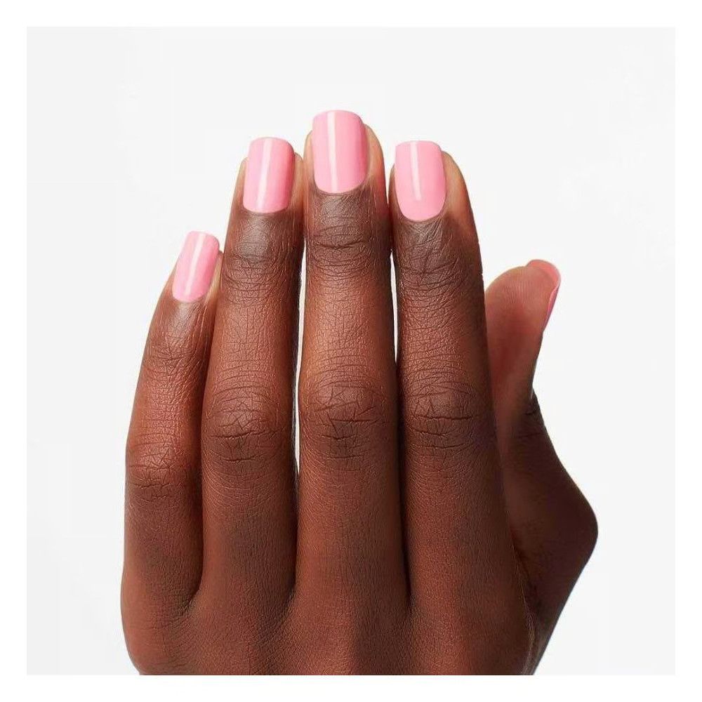 Hand met gelakte nagels. De nagels zijn roze en vierkant van vorm.