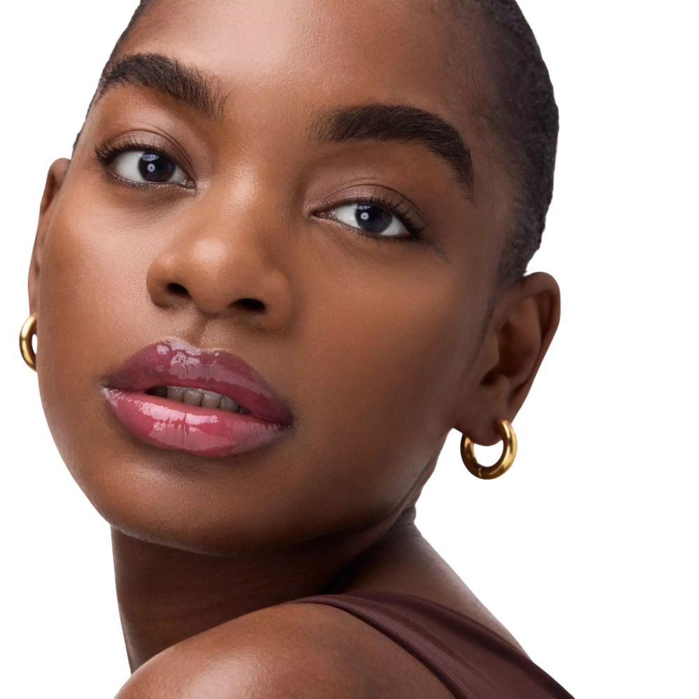 Portret van een vrouw met lipgloss. Gouden oorringen. Huidskleur: donker.