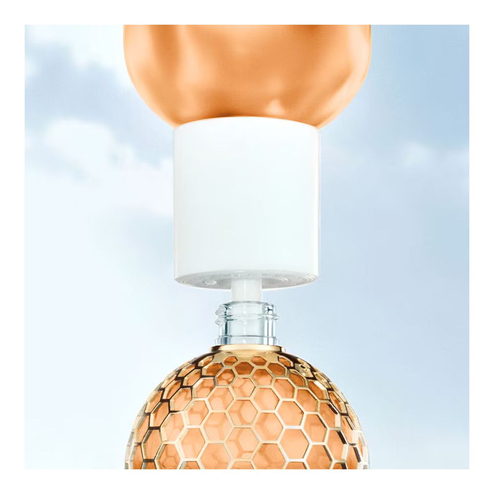 Fles met gouden inhoud. Witte sluiting. Gouden honingraatpatroon. Glazen fles.