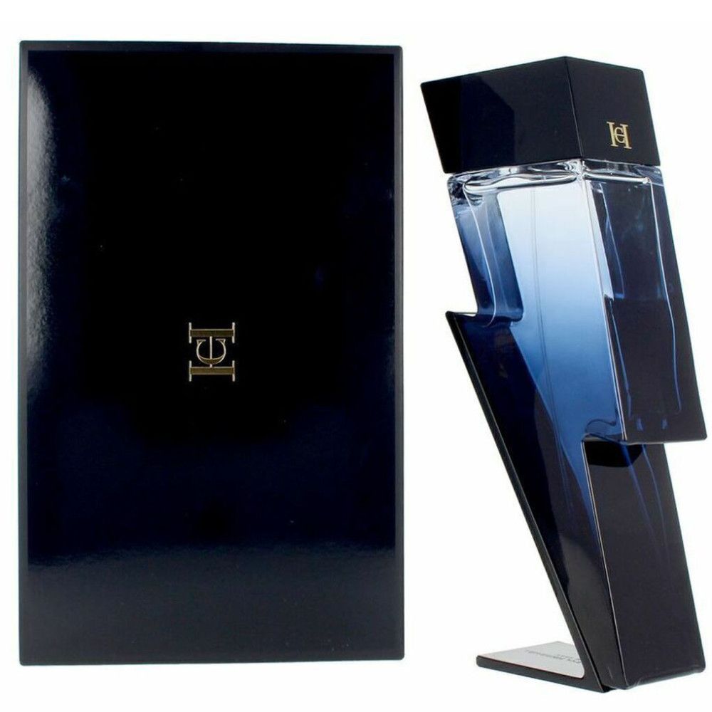 Donkerblauwe fles in bliksemvorm en zwarte verpakking met goudkleurig logo. Fles staat op een standaard.