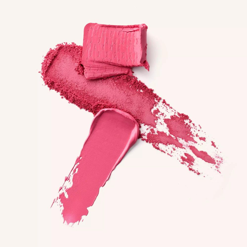 Échantillons de blush crème et poudre roses. Morceau de crème en haut, poudre en dessous et une trace de crème. Sur fond clair.