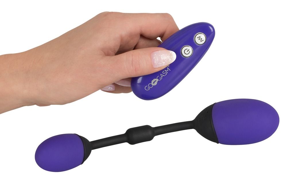 Paarse vibrator met afstandsbediening in hand.