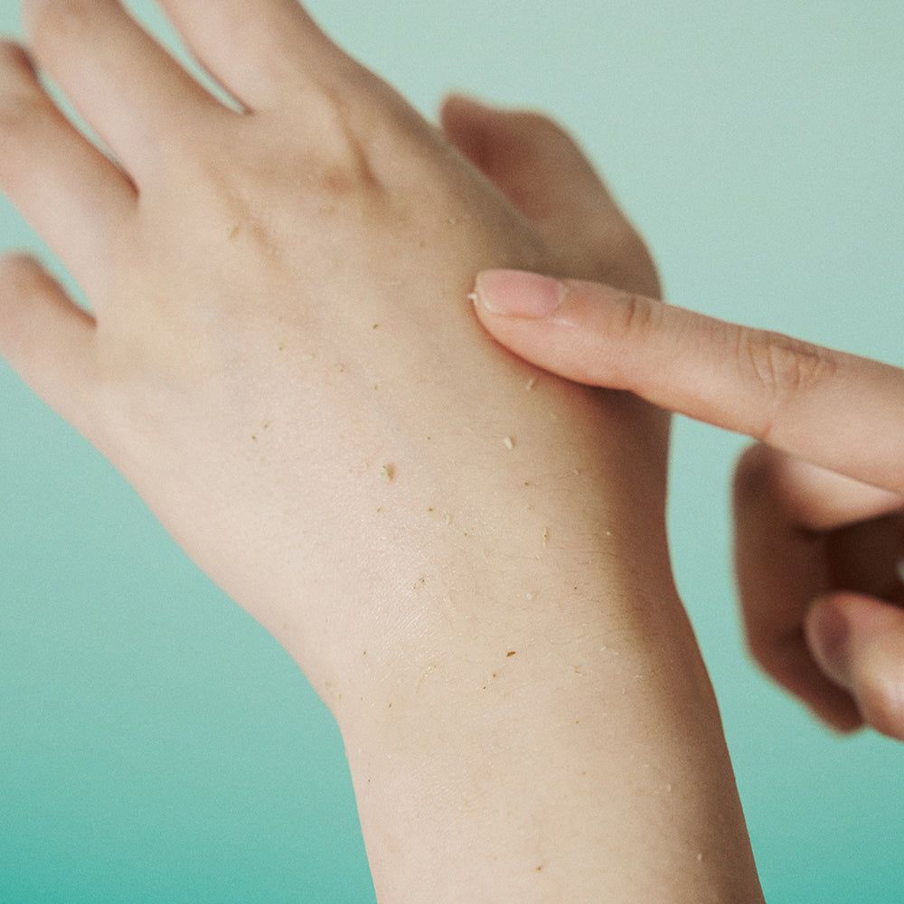 Hand met productresten. Gel aangebracht op hand. Vinger raakt de huid aan.