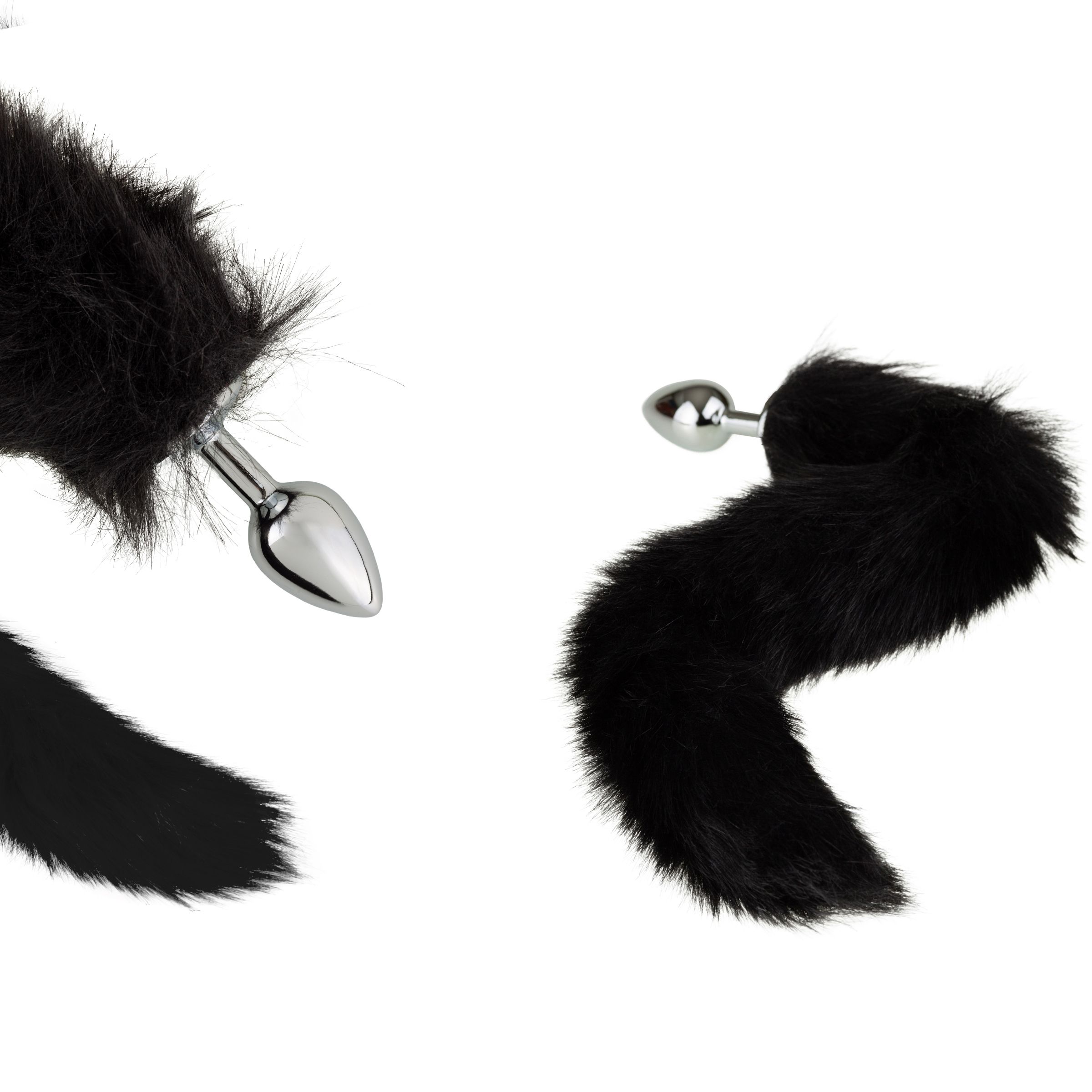 Twee zwarte anale plugs met harige staart. De plugs hebben een glanzend, metalen oppervlak.