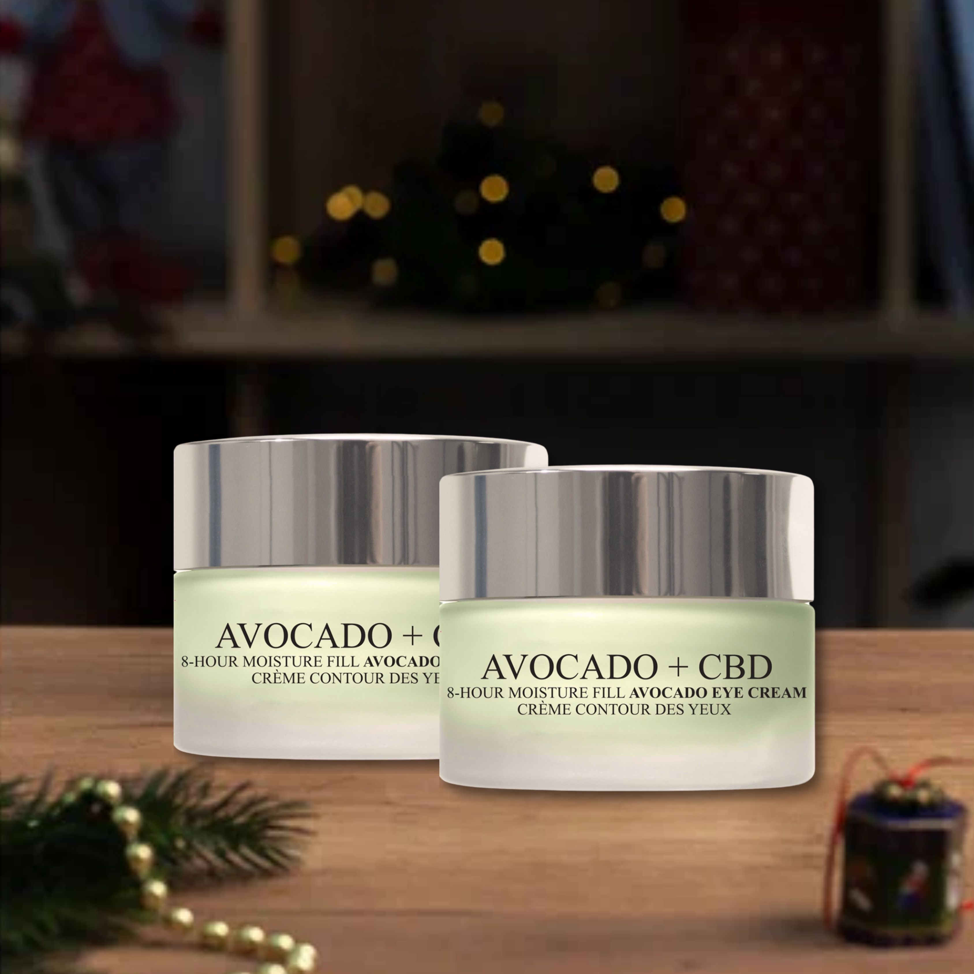 Deux pots de crème pour les yeux avec couvercles. Inscription: Avocado + CBD, 8-Hour Moisture Fill Avocado Eye Cream, Crème Contour des Yeux. Sur bois.
