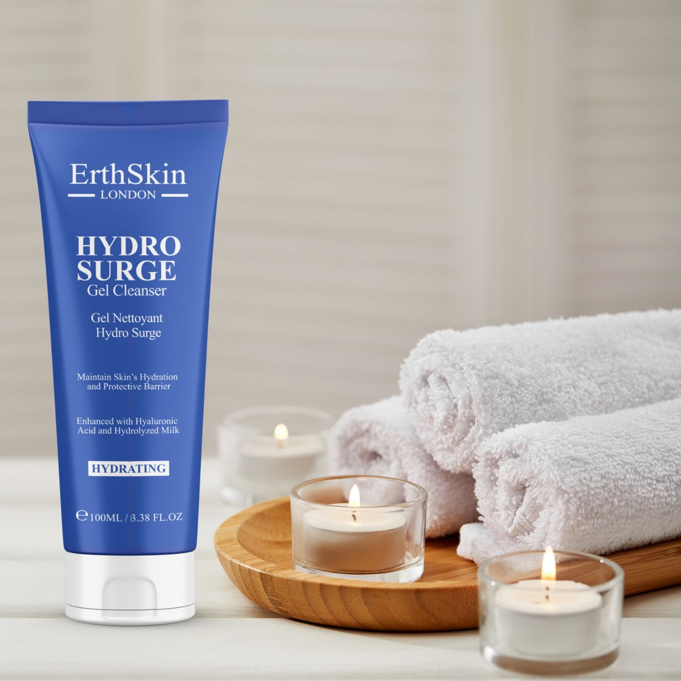Tube bleue HYDROSURGE Gel Cleanser. Texte: ErthSkin London, HYDROSURGE Gel Cleanser. Sur un plateau avec bougies et serviettes.